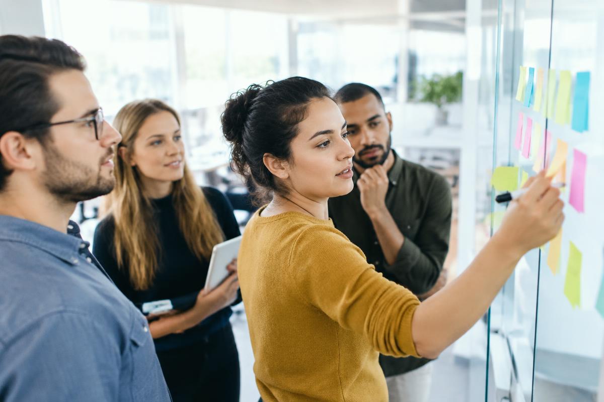 Équipe d'entrepreneurs préparant un projet sur un tableau